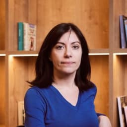 headshot of Noemí Planas in front of a bookshelf.